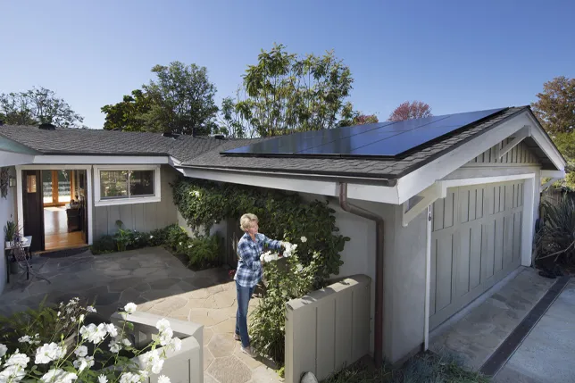 Pannelli Sunpower M Class installati su un tettoia per auto con una donna nel giardino